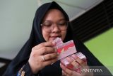 Petugas Disdukcapil Kota Pontianak memeriksa hasil cetakan puluhan Kartu Identitas Anak (KIA) saat melaksanakan layanan jemput bola di Sekolah Dasar Negeri (SDN) 10 Pontianak Utara, Kalimantan Barat, Selasa (20/5/2025). Sebanyak 118.557 anak atau 63,45 persen dari total anak di Kota Pontianak telah memiliki Kartu Identitas Anak (KIA) melalui program Pelayanan Cetak Kartu Identitas Anak Sehari Jadi (PECI HAJI) yang menyasar anak usia sekolah dengan sistem jemput bola di sekolah maupun di ruang publik. ANTARA FOTO/Jessica Wuysang