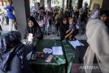 Petugas menyerahkan uang tunai kepada warga saat penyaluran bantuan sosial di Kota Tangerang, Banten, Selasa (12/8/2025). Pemerintah Provinsi Banten telah menyalurkan bantuan sosial senilai Rp9,25 miliar kepada 18.500 keluarga penerima manfaat (KPM) dari total anggaran Rp18,8 miliar untuk 37.741 KPM pada tahun 2025. ANTARA FOTO/Putra M. Akbar/gp