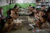 Siswa menyantap makanan bergizi gratis (MBG) di SDN Kunciran 2, Pinang, Kota Tangerang, Banten, Rabu (13/8/2025). Badan Gizi Nasional (BGN) mencatat realisasi APBN untuk program MBG per 11 Agustus 2025 mencapai Rp8,2 triliun yang meliputi pembentukan 5.103 Satuan Pelayanan Pemenuhan Gizi (SPPG) di 38 provinsi dan total penerima manfaat mencapai lebih dari 15 juta orang. ANTARA FOTO/Putra M. Akbar/gp