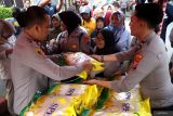 Kapolres Tulungagung AKBP Muhammad Taat Resdi (kiri) ikut membantu melayani pembelian beras subsidi jenis SPHP di depan Mapolres Tulungagung, Jawa Timur, Kamis (14/8/2025). Polres Tulungagung bekerja sama dengan Bulog menggelar pasar murah beras jenis SPHP dengan total volume 85 ton yang didistribusikan 19 polsek jajaran dan Mako Polres Tulungagung, dalam upaya stabilisasi harga pasar beras di masyarakat. ANTARA Jatim/Destyan Sujarwoko/mas.