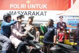 Polisi membantu relawan banpol yang membawa dua karung beras SPHP menyeberangi jalan raya di depan pos pasar murah beras depan Mapolres Tulungagung, Jawa Timur, Kamis (14/8/2025). Polres Tulungagung bekerja sama dengan Bulog menggelar pasar murah beras jenis SPHP dengan total volume 85 ton yang didistribusikan 19 polsek jajaran dan Mako Polres Tulungagung, dalam upaya stabilisasi harga pasar beras di masyarakat. ANTARA Jatim/Destyan Sujarwoko/mas.