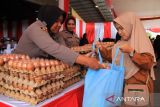 Petugas kepolisian melayani warga yang membeli telur dalam acara Gerakan Pangan Murah di Polda Kalimantan Barat, Kamis (14/8/2025). Gerakan Pangan Murah yang digelar Polda Kalbar dengan menyediakan dua ribu paket sembako seharga di bawah pasaran bagi masyarakat terdampak lonjakan harga tersebut guna menjaga stabilitas dan pasokan bahan pokok serta mendukung intervensi pemerintah dalam pengendalian inflasi. ANTARA FOTO/Jessica Wuysang