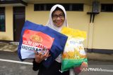 Seorang warga memperlihatkan tas berisi paket sembako yang dibeli pada acara Gerakan Pangan Murah di Polda Kalbar, Kamis (14/8/2025). Gerakan Pangan Murah yang digelar Polda Kalbar dengan menyediakan dua ribu paket sembako seharga di bawah pasaran bagi masyarakat terdampak lonjakan harga tersebut guna menjaga stabilitas dan pasokan bahan pokok serta mendukung intervensi pemerintah dalam pengendalian inflasi. ANTARA FOTO/Jessica Wuysang