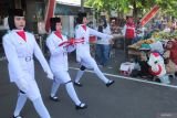 Paskibraka membawa bendera Merah Putih untuk dikibarkan saat upacara di pasar di Jalan Karang Menjangan, Surabaya, Jawa Timur, Minggu (17/8/2025). Upacara pengibaran bendera Merah Putih dalam rangka memperingati HUT ke-80 Kemerdekaan RI tersebut diikuti warga dan pedagang pasar. Antara Jatim/Didik Suhartono/um