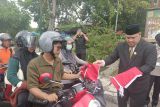 Ketua DPRD Kota Banjarbaru, Kalimantan Selatan Gusti Rizky Sukma Iskandar Putera membagikan bendera merah putih kepada salah satu pengendara sepeda motor saat gerakan pembagian bendera yang dilaksanakan Pemkot Banjarbaru di seberang Tugu Nol Kilometer Kota Banjarbaru, Ahad (17/8/2025). Pembagian dilakukan bersama Wali Kota Erna Lisa Halaby dan Wakil Wali Kota Wartono disambut antusias penerima bendera kebangsaan Indonesia itu.