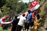 Warga mengikuti kirab bendera merah putih  menuju bantaran Sungai Brantas, Penanggungan, Malang, Jawa Timur, Minggu (17/8/2025). Kirab dan pembentangan kain merah putih sepanjang 80 meter di bantaran sungai tersebut digelar sebagai bagian dari peringatan HUT ke-80 Kemerdekaan RI sekaligus mengkampanyekan gerakan kepedulian lingkungan dengan tidak membuang sampah rumah tangga di sungai. ANTARA Jatim/Ari Bowo Sucipto/mas.
