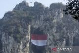 Atlet panjat tebing FPTI bersama anggota dari berbagai komunitas panjat tebing mengibarkan bendera Merah Putih raksasa di Tebing Hawu, Padalarang, Kabupaten Bandung Barat, Jawa Barat, Minggu (17/8/2025). Upacara dan pengibaran bendera raksasa di kawasan tebing hawu tersebut dilakukan dalam rangka memperingati HUT Kemerdekaan Ke-80 Republik Indonesia sekaligus upaya melestarikan kawasan konservasi Karst Citatah. ANTARA FOTO/Abdan Syakura/agr