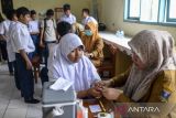 Petugas kesehatan Puskesmas Cikeusal memeriksa telinga siswa saat cek kesehatan gratis (CKG) di SMP Negeri 3 Cikeusal, Kabupaten Serang, Banten, Selasa (19/8/2025). Pemerintah mengalokasikan sebanyak Rp244 triliun pada Rancangan Anggaran Pendapatan dan Belanja Negara (RAPBN) 2026 untuk memastikan layanan kesehatan yang berkualitas dan merata bagi seluruh rakyat Indonesia. ANTARA FOTO/Muhammad Bagus Khoirunas/gp