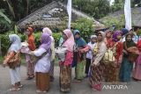 Warga membawa makanan saat tradisi Nyuguh di Kampung Kuta, Kabupaten Ciamis, Jawa Barat, Selasa (19/8/2025). Tradisi Adat Nyuguh yang ditetapkan sebagai warisan budaya tak benda itu, merupakan bentuk rasa syukur warga terhadap Tuhan yang telah memberikan panen yang berlimpah sekaligus ritual tolak bala untuk menyambut bulan Mulud sekaligus melestarikan kearifan lokal. ANTARA FOTO/Adeng Bustomi/agr