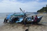 Sejumlah nelayan mengevakuasi perahu wisata yang rusak dihantam akibat gelombang air laut di Wisata Bahari Pasir Putih, Kecamatan Bungatan, Situbondo, Jawa Timur, Rabu (20/8/2025). Sebanyak 20 perahu wisata yang ditambatkan tersebut mengalami kerusakan setelah dihantam gelombang laut yang disertai angin kencang pada Selasa (19/8) malam. ANTARA Jatim/Seno/mas.