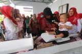 Petugas mengukur berat badan bayi saat layanan posyandu di Kelurahan Pojok, Kota Kediri, Jawa Timur, Kamis (21/8/2025). Pemerintah berupaya terus menurunkan angka kematian bayi (AKB) usia 0-1 tahun dengan target 12 per 1.000 kelahiran hidup pada tahun 2030 sehingga mulai terlihat pekembangannya melalui data Badan Pusat Statistik (BPS) yang menyebutkan penurunan AKB dalam beberapa tahun terakhir yakni 16,9 per 1.000 kelahiran tahun 2020, 16,2 tahun 2021, 15,2 tahun 2022, 14,8 tahun 2023, dan 14,1 per 1.000 kelahiran pada tahun 2024. ANTARA Jatim/Prasetia Fauzani/mas.