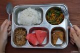 Siswa bersiap menyantap makanan saat pelaksanaan Makan Bergizi Gratis (MBG) perdana di SMP Negeri 2 Tabanan, Desa Delod Peken, Tabanan, Bali, Kamis (21/8/2025). Program MBG yang perdana digelar di wilayah desa tersebut melayani lima sekolah dengan jumlah 3.200 siswa untuk meningkatkan status gizi dan kesehatan. ANTARA FOTO/Nyoman Hendra Wibowo/wsj.
