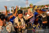 Menteri Perumahan dan Kawasan Permukiman Maruarar Sirait menarik kuda yang ditunggangi oleh warga saat tiba untuk menyerahkan kunci rumah subsidi di Kawasan Pabrik Kahatex, Kabupaten Sumedang, Jawa Barat, Jumat (22/8/2025). Kementerian Perumahan dan Kawasan Permukiman bersama Pemerintah Provinsi Jawa Barat, Bank BJB dan Bank BJB Syariah melakukan serah terima 1.080 kunci rumah subsidi untuk masyarakat berpenghasilan rendah di berbagai wilayah di Jawa Barat secara massal melalui daring dan luring guna mendorong dan menyukseskan program tiga juta rumah dari pemerintah pusat. ANTARA FOTO/Raisan Al Farisi/agr