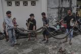 Sejumlah warga membawa ular piton atau sanca kembang (Malayopython reticulatus) yang berhasil ditangkap di area Pemakaman Umum (TPU) Kelurahan Maliaro Ternate, Maluku Utara, Jumat (22/8/2025). Penangkapan dua ekor ular piton dengan panjang sekitar 2,25 meter  tersebut bermula ketika salah satu warga membersihkan area pemakaman umum, penemuan membuat geger warga setempat yang dikhawatirkan membahayakan keselamatan.ANTARA FOTO/Andri Saputra/IWY