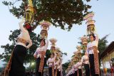 Sejumlah perempuan Bali menjunjung gebogan atau sesajen berisi buah, kue, bunga dan hiasan janur saat parade mapeed pada pembukaan Tanah Lot Art & Food Festival 2025 di Daya Tarik Wisata (DTW) Tanah Lot, Tabanan, Bali, Jumat (22/8/2025). Kegiatan yang digelar pada 22-25 Agustus 2025 tersebut mengusung tema Prayajana Samudrasya Adiswara dengan melibatkan 23 desa adat dalam bentuk parade dan pertunjukan seni untuk meningkatkan jumlah kunjungan wisatawan di objek wisata itu yang ditargetkan mencapai 30.000 orang selama festival. ANTARA FOTO/Nyoman Hendra Wibowo/wsj.