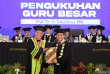 Rektor Universitas Muhammadiyah (UM) Surabaya Mundakir (kanan) menyerahkan surat keputusan (SK) kepada Guru Besar UMS yang baru Prof. Dr. dr. Sukadiono, MM (kiri) saat pengukuhan di UM Surabaya, Jawa Timur, Sabtu (23/8/2025). Sukadiono dikukuhkan menjadi guru besar UM Surabaya dalam bidang Fisiologi Olahraga. ANTARA Jatim/Moch Asim.