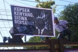 Dua siswa memasang poster saat aksi unjuk rasa di halaman SMAN 2 Situbondo, Jawa Timur, Senin (25/8/2025). Dalam aksinya 1.075 siswa tersebut memprotes kebijakan kepala sekolah, Syaiful Bahri yang telah menebang pohon di area sekolah karena sekolah tersebut berstatus Adiwiyata. Antara Jatim/Seno/um