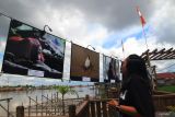 Pengunjung memperhatikan karya foto yang dipajang pada Pameran Ragam Hayati Kalbar di bantaran Sungai Kapuas, Pontianak, Kalimantan Barat, Minggu (24/8/2025). Pameran foto yang merupakan rangkaian kegiatan Kolase Journalist Camp 2025 yang digelar Yayasan Kolase tersebut menampilkan sejumlah karya tentang keanekaragaman hayati Kalimantan Barat sebagai upaya meningkatkan kesadaran publik terhadap pentingnya menjaga kelestarian lingkungan. ANTARA FOTO/Jessica Wuysang/tom.