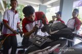 Siswa memberikan cairan pelumas rem ke sepeda motor pelanggan saat kegiatan Teaching Factory di SMK Negeri 2 Kota Tangerang, Banten, Selasa (26/8/2025). Kementerian Pendidikan Dasar dan Menengah menyasar 450 SMK dalam Program Pengajaran Berbasis Pabrik (Teaching Factory) dengan menggunakan skema kolaborasi dan reguler yang merupakan bagian dari Program Pengembangan SMK Tahun 2025 guna menyiapkan sumber daya lulusan SMK yang kompeten dan relevan dengan kebutuhan dunia kerja. ANTARA FOTO/Putra M. Akbar/gp