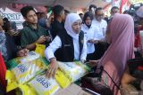 Gubernur Jawa Timur Khofofah Indar Parawansa (tengah) memberikan beras Stabilisasi Pasokan dan Harga Pangan (SPHP) secara gratis kepada warga saat meninjau kegiatan Pasar Murah di Kota Kediri, Jawa Timur, Rabu (27/8/2025). Kunjungan kerja gubernur Jawa Timur di sejumlah daerah tersebut guna memastikan ketersediaan kebutuhan pokok berharga murah sebagai upaya pengendalian inflasi dan ketahanan pangan. Antara Jatim/Prasetia Fauzani/um