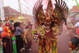 Peserta berjalan memperagakan kostum berbahan bambu kreasinya pada pagelaran Gintangan Bamboo Festival di Banyuwangi, Jawa Timur, Rabu (27/8/2025). Sebanyak 50 peserta menampilkan busana berbahan dasar bambu untuk mempromosikan potensi Desa tersebut sebagai sentra kerajinan bambu. Antara Jatim/Budi Candra Setya/um