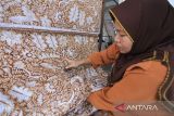 Pembatik menyelesaikan pesanan batik dengan teknik Complongan di workshop Batik Indra desa Terusan, Sindang, Indramayu, Jawa Barat, Jumat (29/8/2025). Complongan merupakan suatu teknik melubangi kain batik dengan deretan jarum dan dilakukan sebelum kain diwarnai menggunakan pewarna alam setelah kain dilapisi lilin hingga menghasilkan motif khas (Complongan) yang dijual Rp150.000 hingga Rp5.000.000 per lembarnya terrgantung motif dan tingkat kerumitan. ANTARA FOTO/Dedhez Anggara/agr