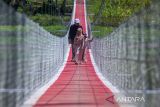Warga berjalan di atas Jembatan Gantung Sungai Cicadas di Desa Karanganyar, Cililin, Kabupaten Bandung Barat, Jawa Barat, Minggu (31/8/2025). Vertical Rescue Indonesia (VRI) membangun jembatan gantung sepanjang 120 meter yang menghubungkan Desa Karanganyar, Kecamatan Cililin dengan Desa Suka Mulya, Kecamatan Cipongkor guna mempermudah masyarakat yang selama ini kesulitan mengakses layanan pendidikan, ekonomi, kesehatan, hingga administrasi kependudukan akibat kondisi geografis yang terisolasi. ANTARA FOTO/Abdan Syakura/agr