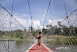 Seorang anak berjalan di atas Jembatan Gantung Sungai Cicadas di Desa Karanganyar, Cililin, Kabupaten Bandung Barat, Jawa Barat, Minggu (31/8/2025). Vertical Rescue Indonesia (VRI) membangun jembatan gantung sepanjang 120 meter yang menghubungkan Desa Karanganyar, Kecamatan Cililin dengan Desa Suka Mulya, Kecamatan Cipongkor guna mempermudah masyarakat yang selama ini kesulitan mengakses layanan pendidikan, ekonomi, kesehatan, hingga administrasi kependudukan akibat kondisi geografis yang terisolasi. ANTARA FOTO/Abdan Syakura/agr
