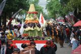 Petugas mengenakan pakaian adat Jawa mengarak tumpeng agung dalam rangkaian kirab pusaka dan pawai budaya di Trenggalek, Jawa Timur, Minggu (31/8/2025). Kirab pusaka dan pawai budaya itu menandai puncak peringatan Hari Jadi ke-831 Kabupaten Trenggalek yang jatuh pada 31 Agustus. ANTARA Jatim/Destyan Sujarwoko/mas.