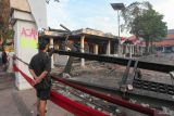 Warga menyaksikan sebagian bangunan Gedung Negara Grahadi yang terbakar pascakerusuhan di Surabaya, Jawa Timur, Minggu (31/8/2025). Bangunan yang terletak di sisi barat Gedung Negara Grahadi itu ludes dibakar sekelompok orang yang anarkis saat melancarkan aksinya pada Sabtu (30/8). ANTARA Jatim/Didik Suhartono/mas.