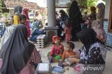 Keluarga penerima manfaat memberikan Makan Bergizi Gratis (MBG) kepada anaknya di Posyandu Kenanga, Desa Utama, Kabupaten Ciamis, Jawa Barat, Senin (1/9/2025). Pemerintah memulai program MBG khusus untuk ibu hamil, ibu menyusui, dan balita melalui posyandu, untuk memperoleh asupan makanan sehat dan bergizi seimbang sebagai strategi efektif untuk mendekatkan layanan gizi kepada masyarakat. ANTARA FOTO/Adeng Bustomi/agr