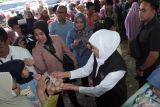 Gubernur Jawa Timur Khofifah Indar Parawansa (kedua kanan) membagikan telur gratis kepada warga saat pasar murah di Sepanjang, Taman, Sidoarjo, Jawa Timur, Kamis (4/9/2025). Pemerintah Provinsi Jawa Timur menggelar pasar murah rutin berkeliling ke berbagai kabupaten/kota guna mendekatkan pemenuhan kebutuhan pokok bagi masyarakat yang tinggal jauh dari pasar tradisional sebagai upaya pengendalian inflasi dan ketahanan pangan. Antara Jatim/Fahmi Alfian/um