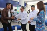Group Head East Region XLSMART Dodik Ariyanto (kedua kiri) bersama Head Direct Channel Region East XLSMART Noval P Wedhasmara (kedua kanan) memberikan cendera mata kepada salah satu pelanggan di XL Center Pemuda, Surabaya, Jawa Timur, Kamis (4/9/2025). Pada Hari Pelanggan Nasional 2025 XLSMART menghadirkan berbagai program apresiasi mulai dari diskon tagihan 50 persen untuk pelanggan XL Prioritas, tukar poin dengan kuota aplikasi favorit bagi pelanggan XL Prabayar hingga hadiah langsung dan voucher menarik untuk pelanggan Smartfren. ANTARA Jatim/Moch Asim.