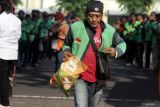 Pengemudi ojek online menerima bantuan beras seusai doa bersama di parkir timur GOR Delta Sidoarjo, Jawa Timur, Jumat (5/9/2025). Pemerintah Kabupaten (Pemkab) Sidoarjo membagikan bantuan beras untuk membantu perekonomian pengemudi ojek online dan mempererat jalinan silaturahmi. Antara Jatim/Umarul Faruq