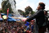 Wakil Bupati Blitar Beky Herdihansah menyiramkan air sisa siraman kepada warga usai tradisi siraman gong kiai pradah di Alun-alun Lodoyo, Blitar, Jawa Timur, Sabtu (6/9/2025). Tradisi turun menurun membersihkan (siraman) benda pusaka berupa gong kuno Kiai Pradah pada 12 Rabiul Awal (Maulid Nabi Muhammad SAW) tersebut sebagai atraksi wisata budaya yang diharapkan mampu menarik para pengunjung dan memberikan dampak positif bagi pariwisata daerah serta perekonomian masyarakat setempat. Antara Jatim/Irfan Anshori/um