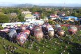 Foto aerial warga menyaksikan balon udara yang diterbangkan di lapangan Sport Centre Limboto, Kabupaten Gorontalo, Gorontalo, Minggu (7/9/2025). Sebanyak 14 balon udara diterbangkan pada Festival Balon Udara yang digelar oleh tokoh masyarakat Gorontalo Rachmat Gobel bersama Kantor Perwakilan Bank Indonesia Gorontalo dan Pemerintah Daerah, dalam upaya promosi pariwisata dan UMKM daerah tersebut. ANTARA/Adiwinata Solihin