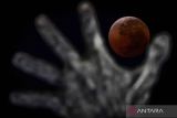 Fase gerhana bulan total terlihat dengan latar Tugu Pembebasan Irian Barat di Lapangan Banteng, Jakarta, Senin (8/9/2025). Gerhana bulan total berwarna merah darah atau blood moon tersebut berlangsung dari fase awal hingga gerhana berakhir sekitar 5 jam 29 menit 48 detik dan dapat disaksikan di seluruh Indonesia. ANTARA FOTO/Bayu Pratama S/rwa/pri.