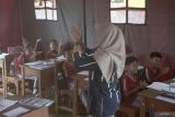 Belasan siswa kelas IV mengikuti kegiatan belajar-mengajar di kelas darurat di SDN 02 Kradinan, Tulungagung, Jawa Timur, Senin (8/9/2025). Aktivitas belajar-mengajar di kelas darurat memanfaatkan tenda pengungsi milik BPBD itu terpaksa dilakukan karena bangunan kelas reguler mereka rusak parah terdampak longsor pada Selasa (19/8/2025). ANTARA Jatim/Destyan Sujarwoko/mas.
