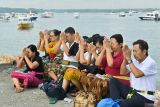 Umat Hindu berdoa saat rangkaian ritual Melukat atau menyucikan diri pada Hari Banyu Pinaruh di Pantai Mertasari, Denpasar, Bali, Minggu (7/9/2025). Ribuan umat Hindu memadati pantai tersebut saat Hari Banyu Pinaruh yang dirayakan satu hari setelah Hari Raya Saraswati untuk menyucikan dan membersihkan diri serta pikiran secara spiritual dengan melakukan ritual Melukat. ANTARA FOTO/Fikri Yusuf/wsj.