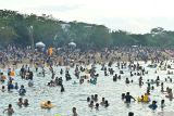 Umat Hindu berendam di air saat melakukan ritual Melukat atau menyucikan diri pada Hari Banyu Pinaruh di Pantai Mertasari, Denpasar, Bali, Minggu (7/9/2025). Ribuan umat Hindu memadati pantai tersebut saat Hari Banyu Pinaruh yang dirayakan satu hari setelah Hari Raya Saraswati untuk menyucikan dan membersihkan diri serta pikiran secara spiritual dengan melakukan ritual Melukat. ANTARA FOTO/Fikri Yusuf/wsj.