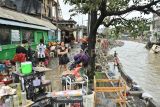 Warga berjalan di dekat bangunan rumah yang diterjang banjir di kawasan Jalan Bukit Barisan, Denpasar, Bali, Rabu (10/9/2025). Sejumlah bangunan seperti ruko, toko dan rumah warga di wilayah Denpasar mengalami kerusakan akibat banjir yang terjadi di sejumlah titik sejak Rabu pagi. ANTARA FOTO/Fikri Yusuf/nz