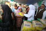Gubernur Jawa Timur Khofifah Indar Parawansa (kedua kanan) memberikan bantuan beras SPHP secara gratis kepada para lansia saat Pasar Murah di Surabaya, Jawa Timur, Jumat (12/9/2025). Pemerintah Provinsi Jawa Timur menggelar pasar murah yang di antaranya menjual beras SPHP 5 kg seharga Rp55.000, MinyaKita Rp13.000 per liter, telur ayam ras Rp22.000 per bungkus dan daging ayam Rp30.000 per kg tersebut sebagai upaya untuk menjaga stabilitas harga kebutuhan pokok sekaligus pengendalian inflasi dan ketahanan pangan. ANTARA Jatim/Moch Asim.