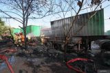 Petugas pemadam kebakaran melakukan pembasahan truk bermuatan peti kemas yang terbakar di Ruang Tunggu Kendaraan (buffer zone) Kalimas, Pelabuhan Kalimas, Surabaya, Jawa Timur, Minggu (14/9/2025). Tim Pemadam Kebakaran PT Pelindo Regional 3 dan Dinas Pemadam Kebakaran dan Penyelamatan (DPKP) Kota Surabaya mengerahkan 15 kendaraan pemadam kebakaran untuk memadamkan kebakaran yang diduga berawal dari ban bekas yang turut membakar dua unit trailer bermuatan petikemas ukuran 20 feet dan dua chasis trailer, dan aktifitas kepelabuhanan di kawasan tersebut tidak terganggu adanya peristiwa tersebut. ANTARA Jatim/Didik Suhartono/mas.