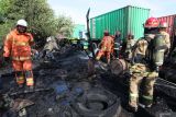 Petugas pemadam kebakaran melakukan pembasahan truk bermuatan peti kemas yang terbakar di Ruang Tunggu Kendaraan (buffer zone) Kalimas, Pelabuhan Kalimas, Surabaya, Jawa Timur, Minggu (14/9/2025). Tim Pemadam Kebakaran PT Pelindo Regional 3 dan Dinas Pemadam Kebakaran dan Penyelamatan (DPKP) Kota Surabaya mengerahkan 15 kendaraan pemadam kebakaran untuk memadamkan kebakaran yang diduga berawal dari ban bekas yang turut membakar dua unit trailer bermuatan petikemas ukuran 20 feet dan dua chasis trailer, dan aktifitas kepelabuhanan di kawasan tersebut tidak terganggu adanya peristiwa tersebut. ANTARA Jatim/Didik Suhartono/mas.
