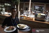 Pramusaji membawa makanan untuk pengunjung di restoran Terminal Wisata Grafika Cikole, Lembang, Kabupaten Bandung Barat, Jawa Barat, Senin (15/9/2025). Pemerintah berencana memperluas cakupan penerima insentif pajak penghasilan (PPh) pasal 21 ditanggung pemerintah (DTP) untuk pekerja dengan gaji di bawah Rp10 juta di sektor hotel, restoran, dan katering (horeka) atau pariwisata sebagai bagian dari stimulus ekonomi. ANTARA FOTO/Abdan Syakura/agr