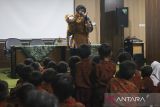 Pendongeng Ihan Imtihan menyampaikan cerita dongeng kepada siswa sekolah dasar saat peringatan Hari Kunjung Perpustakaan di Gedung Dinas Perpustakaan dan Kearsipan Provinsi Banten, Kota Serang, Banten, Rabu (17/9/2025). Dinas Perpustakaan dan Kearsipan Provinsi Banten menggelar beragam kegiatan pada Hari Kunjung Perpustakaan 2025 di antaranya kelas pemustaka, dongeng anak, dan seminar literasi yang bertujuan untuk menjadikan perpustakaan sebagai tempat yang menyenangkan sekaligus membangun kebiasaan gemar membaca kepada masyarakat. ANTARA FOTO/Angga Budhiyanto/gp