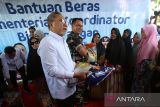 Menteri Koordinator Bidang Pangan, Zulkifli Hasan (kedua kiri) menyerahkan bansos pangan beras secara simbolis kepada warga di desa Geuucheu Komplek, Banda Aceh, Aceh, Kamis (18/9/2025). Kunjungan Menteri Koordinator Bidang Pangan, Zulkifli Hasan di Aceh  dalam rangka menyalurkan bansos beras pangan dan meninjau Koperasi Desa Merah Putih (KDMP)  serta memberikan arahan kepada pemerintah daerah memperkuat ketahanan pangan mulai dari desa melalui usaha kreatif, inovatif dan produktif. ANTARA FOTO/Ampelsa.