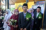 Pasangan pengantin jalan bersama pada acara Nikah Masal di Pelinggihan Dinas Pariwisata, Banyuwangi, Jawa Timur, Kamis (18/9/2025). Sebanyak delapan pasangan dari keluarga kurang mampu mengikuti Nikah dan Resepsi massal yang difasilitasi Al Irsyad AL Islamiyyah agar pernikahan mereka sah secara negara. ANTARA Jatim/Budi Candra Setya/mas.