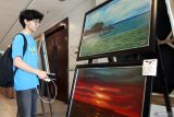 Pengunjung melihat lukisan yang dipajang dalam pameran bertajuk Lintas Jalur Langit di Malang, Jawa Timur, Kamis (18/9/2025). Pameran tersebut menampilkan sekitar 60 karya lukisan dengan mengangkat makna simbolisasi tentang perjalanan spiritual maupun harapan kehidupan dari 20 seniman yang tergabung dalam komunitas Asta Cita Perupa Malang (ACPM) dan berlangsung hingga Kamis (25/9). ANTARA Jatim/Ari Bowo Sucipto/mas.