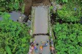 Foto udara kondisi jembatan putus di Desa Kandangtepus, Kecamatan Senduro, Lumajang, Jawa Timur, Jumat (19/9/2025). Jembatan berukuran 8x4 meter yang menjadi akses penghubung antar kecamatan itu putus akibat dinding penahan terkikis banjir dan telah diasesmen pihak terkait untuk proses penanganan. ANTARA Jatim/Irfan Sumanjaya/mas.
